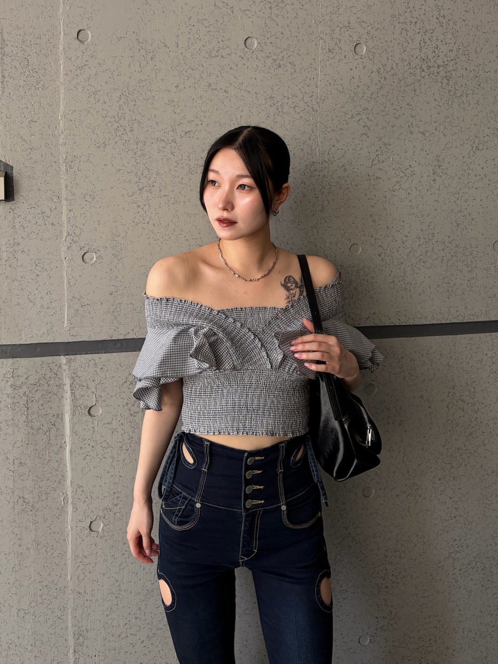 グレー系のTシャツ/カットソー、ブルー系のデニムパンツ、ブラック系のハンドバッグを着用したレディースの夏コーディネートの4枚目の写真