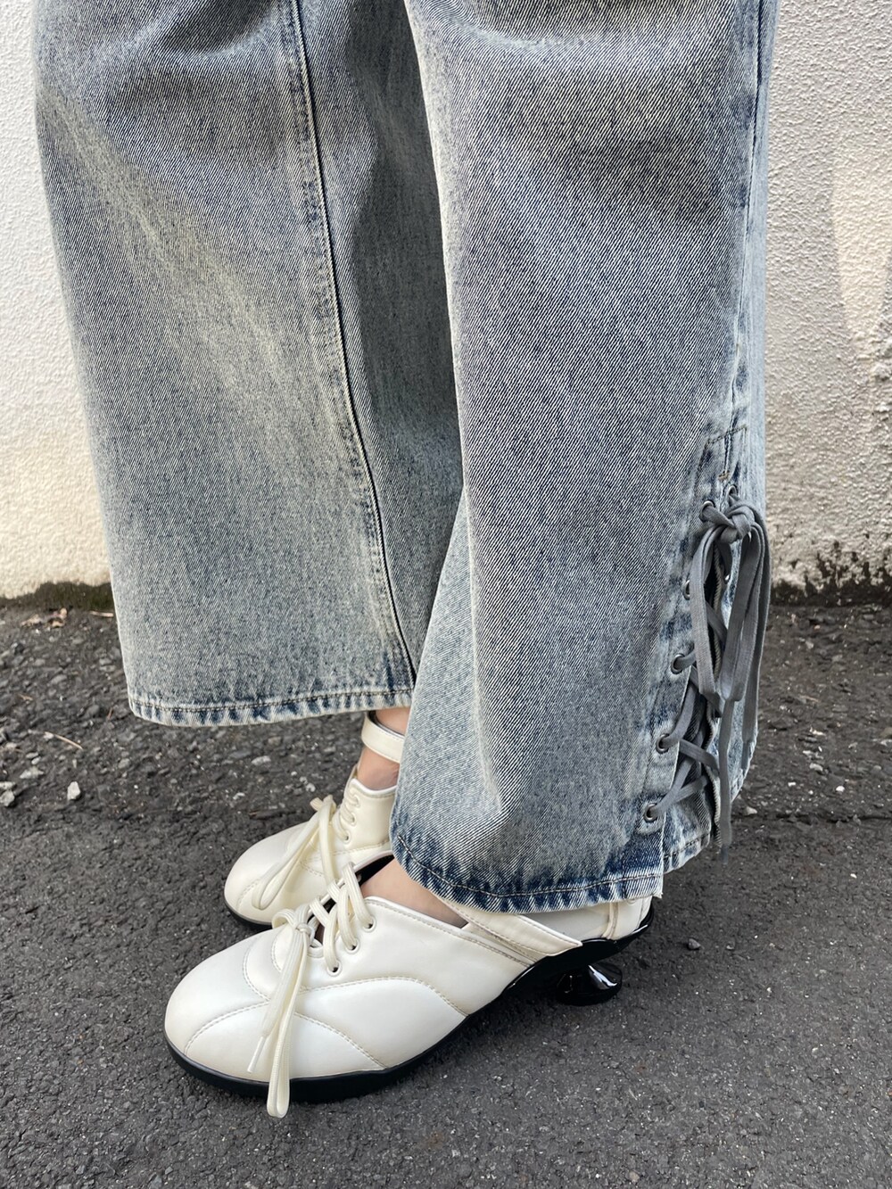 ブルー系のタンクトップ、ブルー系のデニムパンツ、ホワイト系のスニーカーを着用したレディースの春コーディネートの5枚目の写真