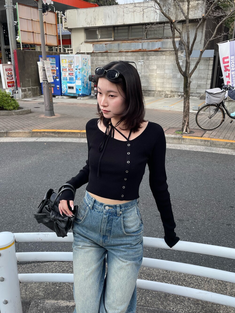 ブラック系のニット/セーター、ブルー系のデニムパンツ、ブラック系のブーツを着用したレディースの冬コーディネートの2枚目の写真