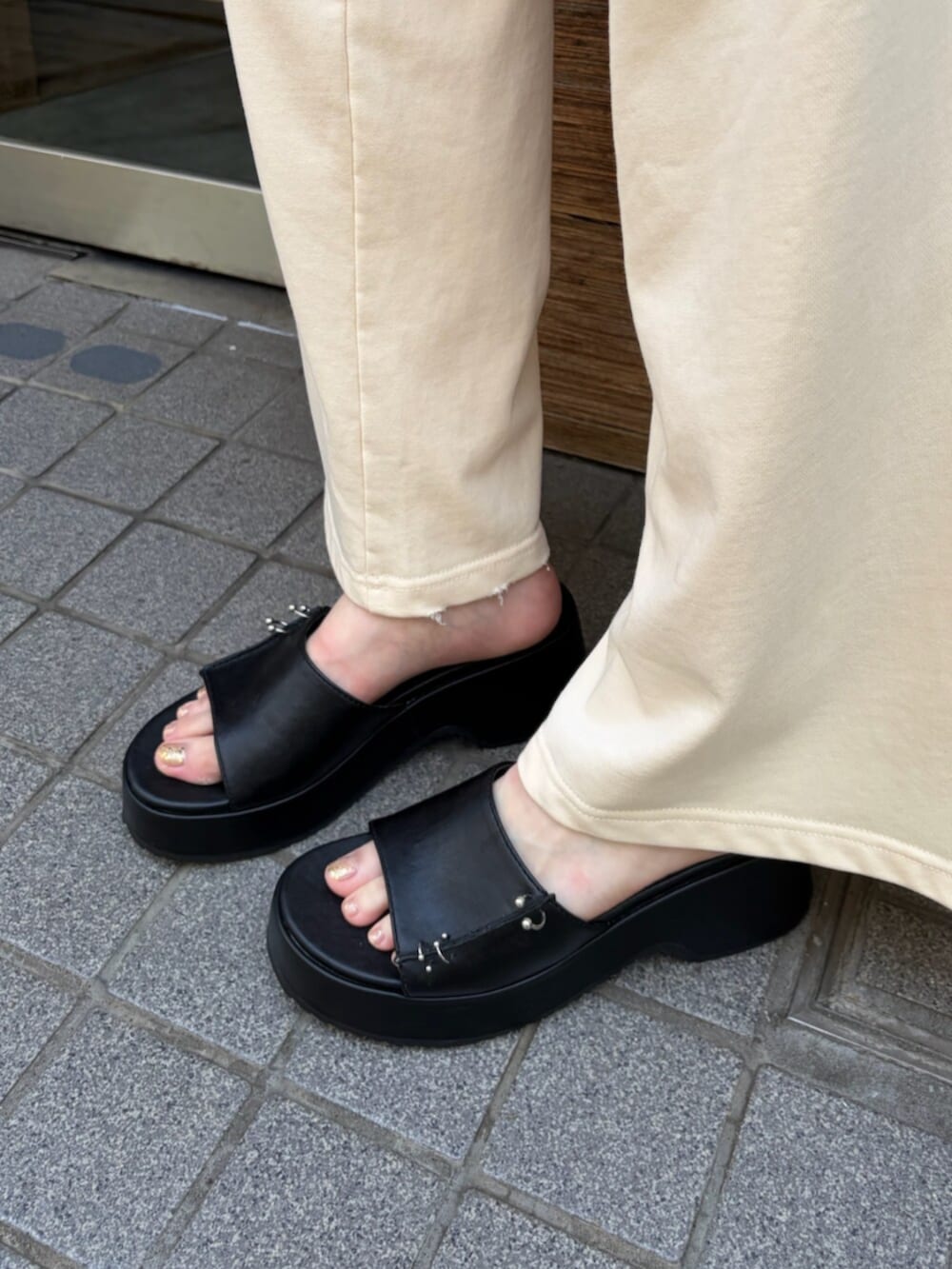 ホワイト系のスウェット、ブラック系のサンダル、ホワイト系のスウェットパンツを着用したレディースの夏コーディネートの6枚目の写真
