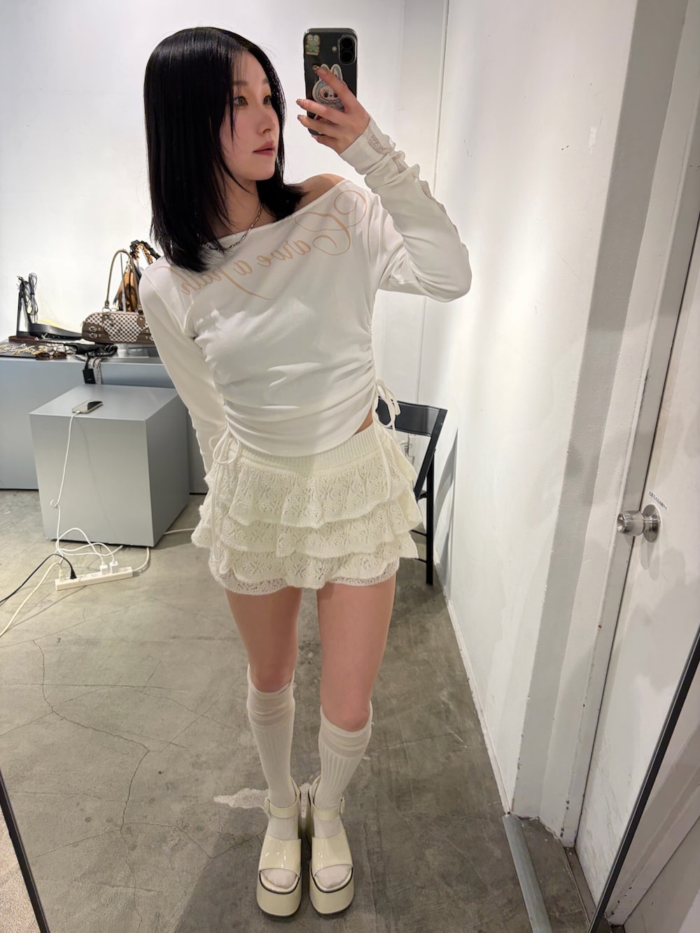 ホワイト系のTシャツ/カットソー、ホワイト系のスカート、ホワイト系のサンダルを着用したレディースの春コーディネートの4枚目の写真