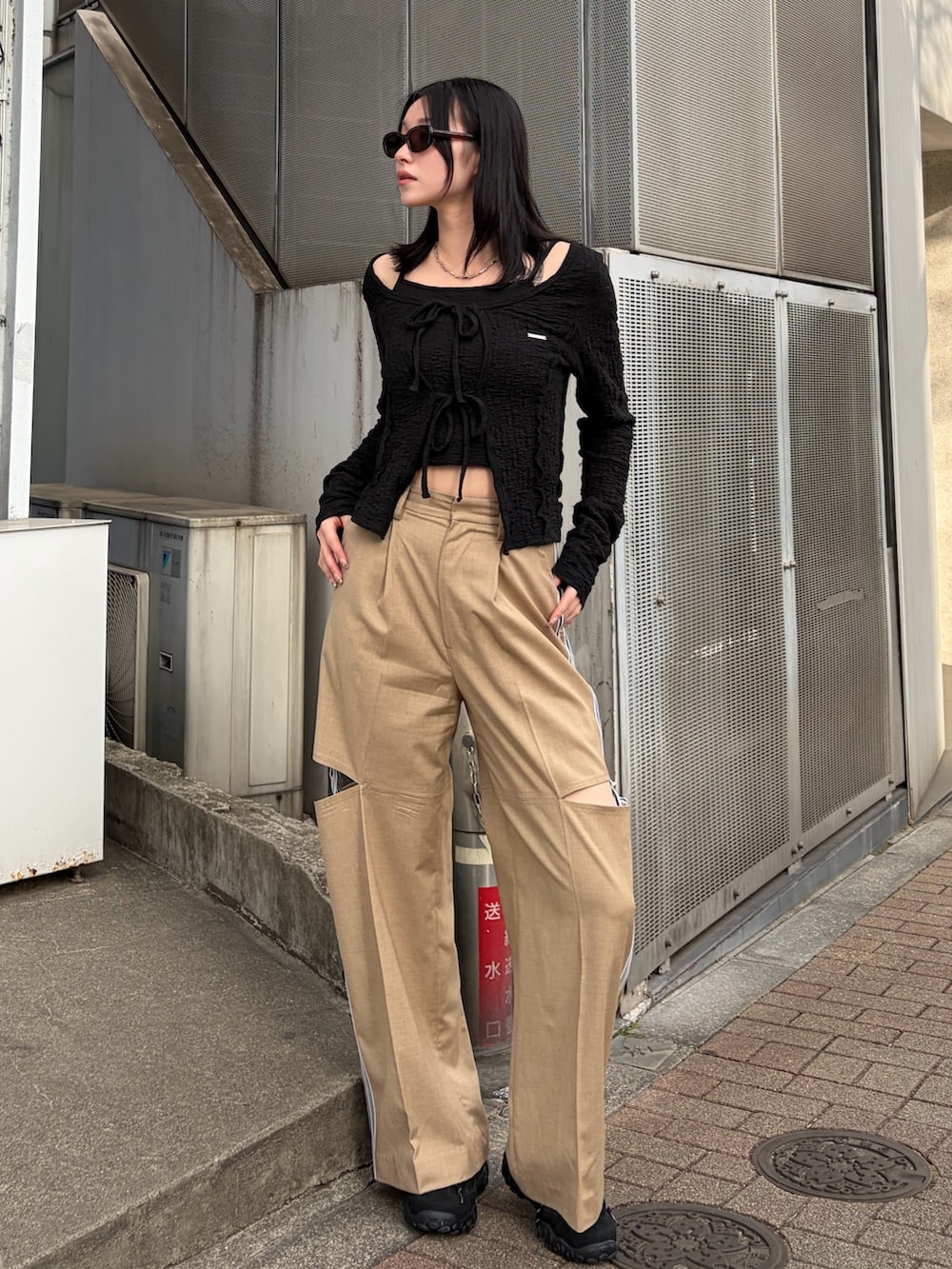 ブラック系のTシャツ/カットソー、ベージュ系のその他パンツ、ブラック系のスニーカーを着用したレディースの春コーディネートの2枚目の写真