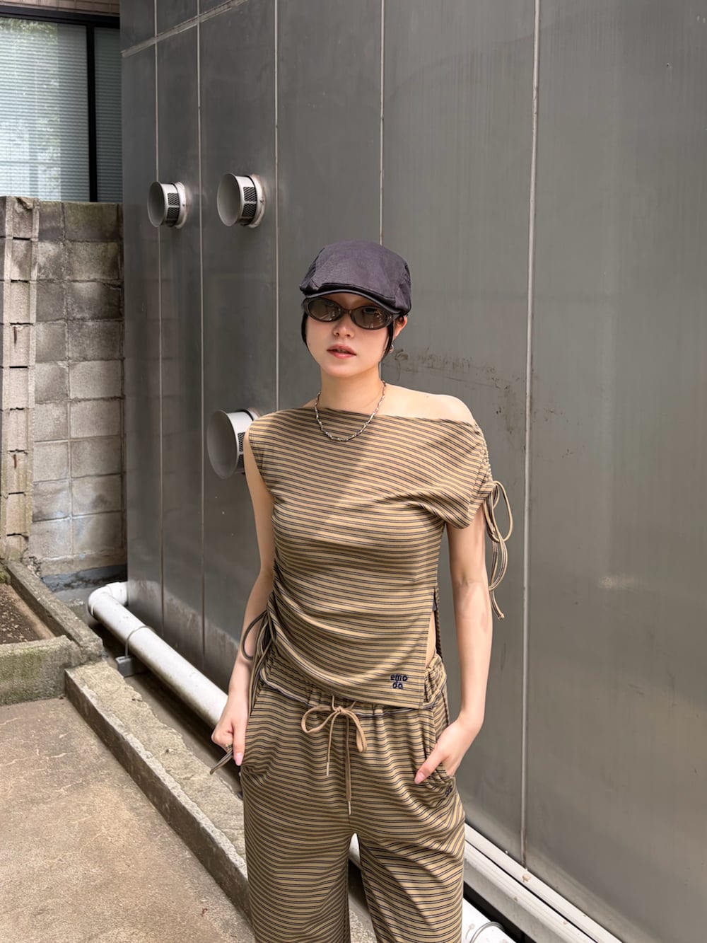 グリーン系のTシャツ/カットソー、グリーン系のその他パンツ、ブラック系のスニーカーを着用したレディースの夏コーディネートの5枚目の写真