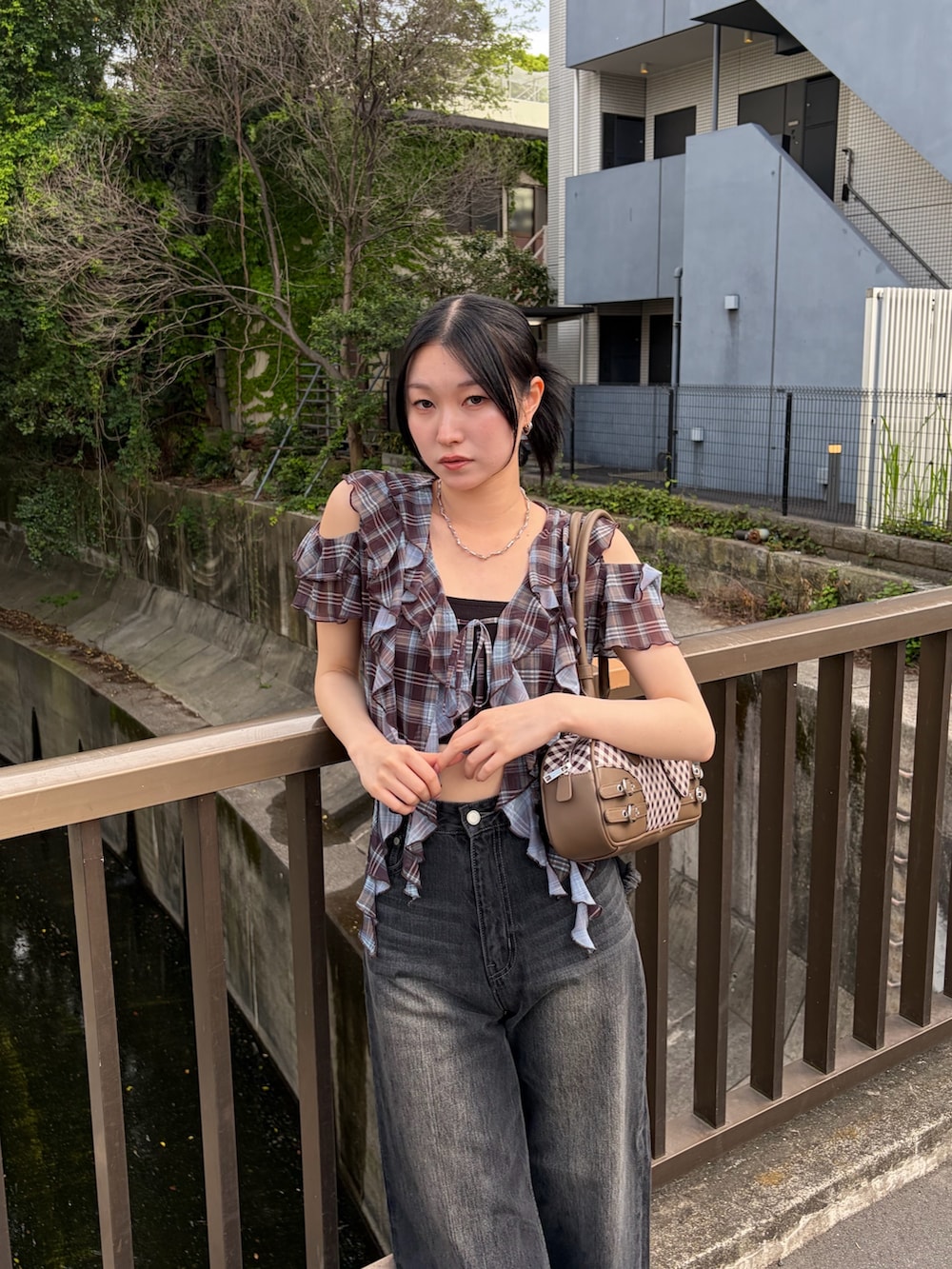 ブラック系のキャミソール、ブラウン系のTシャツ/カットソー、ブラウン系のハンドバッグを着用したレディースの春コーディネートの6枚目の写真