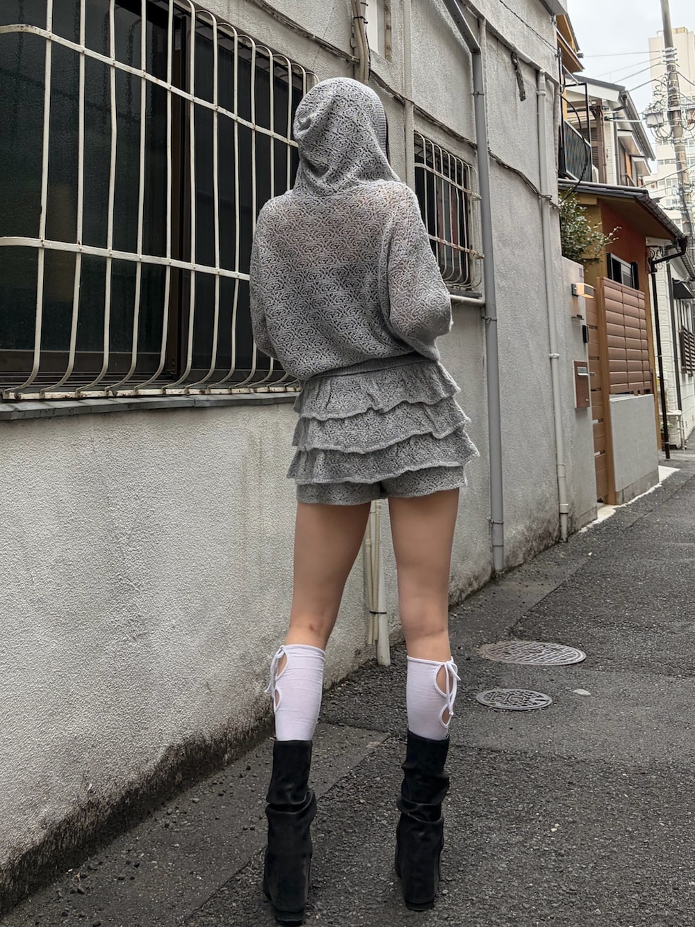 グレー系のパーカー、グレー系のスカート、ブラック系のサンダルを着用したレディースの春コーディネートの3枚目の写真