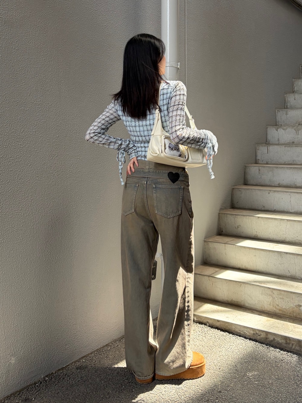 ブルー系のTシャツ/カットソー、ブラウン系のデニムパンツ、ホワイト系のハンドバッグを着用したレディースの秋コーディネートの3枚目の写真