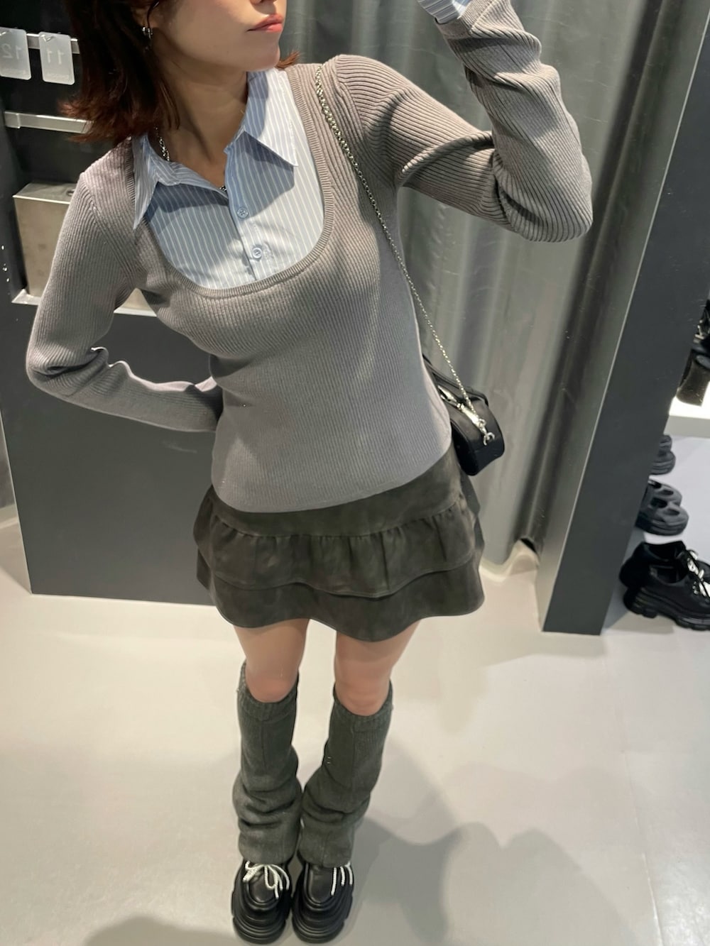 グレー系のニット/セーター、グレー系のスカート、ブラック系のローファーを着用したレディースの秋コーディネートの4枚目の写真