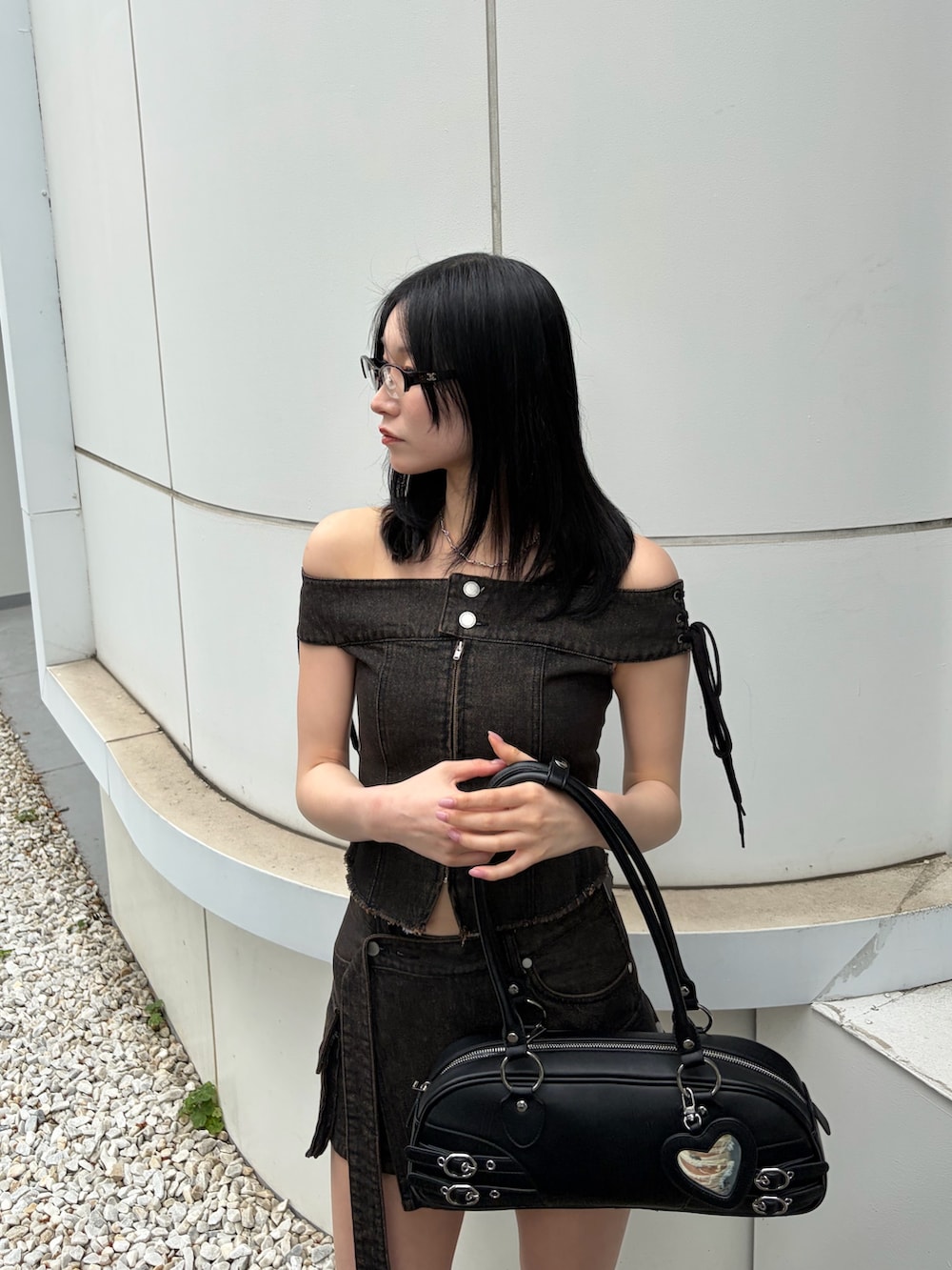 ブラック系のハンドバッグ、ブラウン系のTシャツ/カットソー、ブラウン系のスカートを着用したレディースの春コーディネートの5枚目の写真