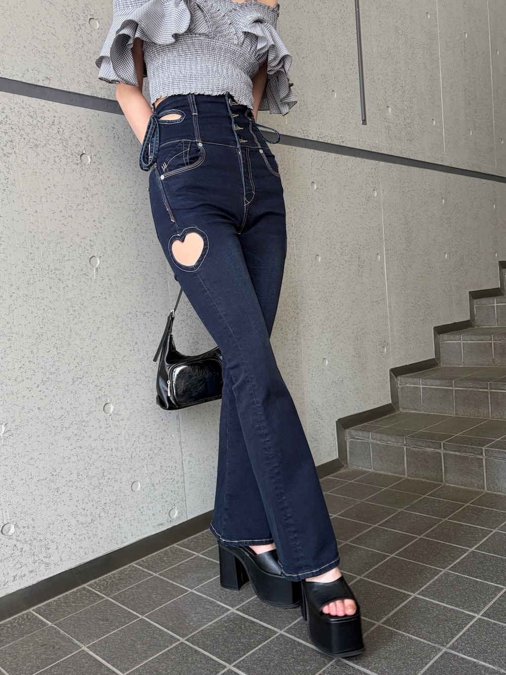 グレー系のTシャツ/カットソー、ブルー系のデニムパンツ、ブラック系のハンドバッグを着用したレディースの夏コーディネートの5枚目の写真