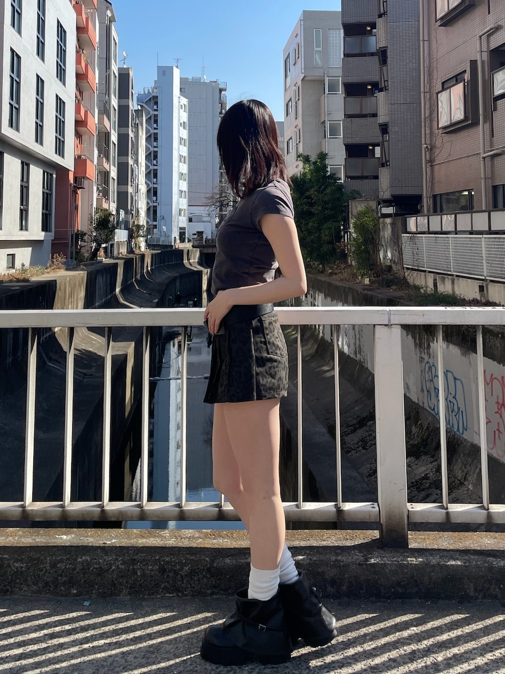 ブラック系のTシャツ/カットソー、ブラウン系のその他パンツ、ブラック系のブーツを着用したレディースの春コーディネートの2枚目の写真