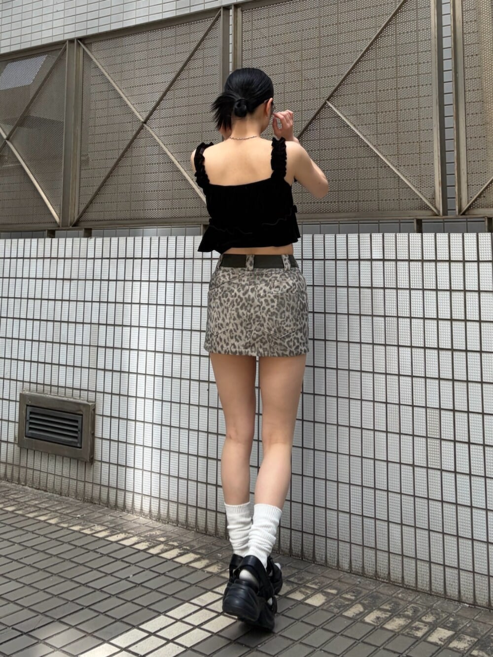 ブラック系のサンダル、ブラック系のタンクトップ、ベージュ系のスカートを着用したレディースの夏コーディネートの4枚目の写真