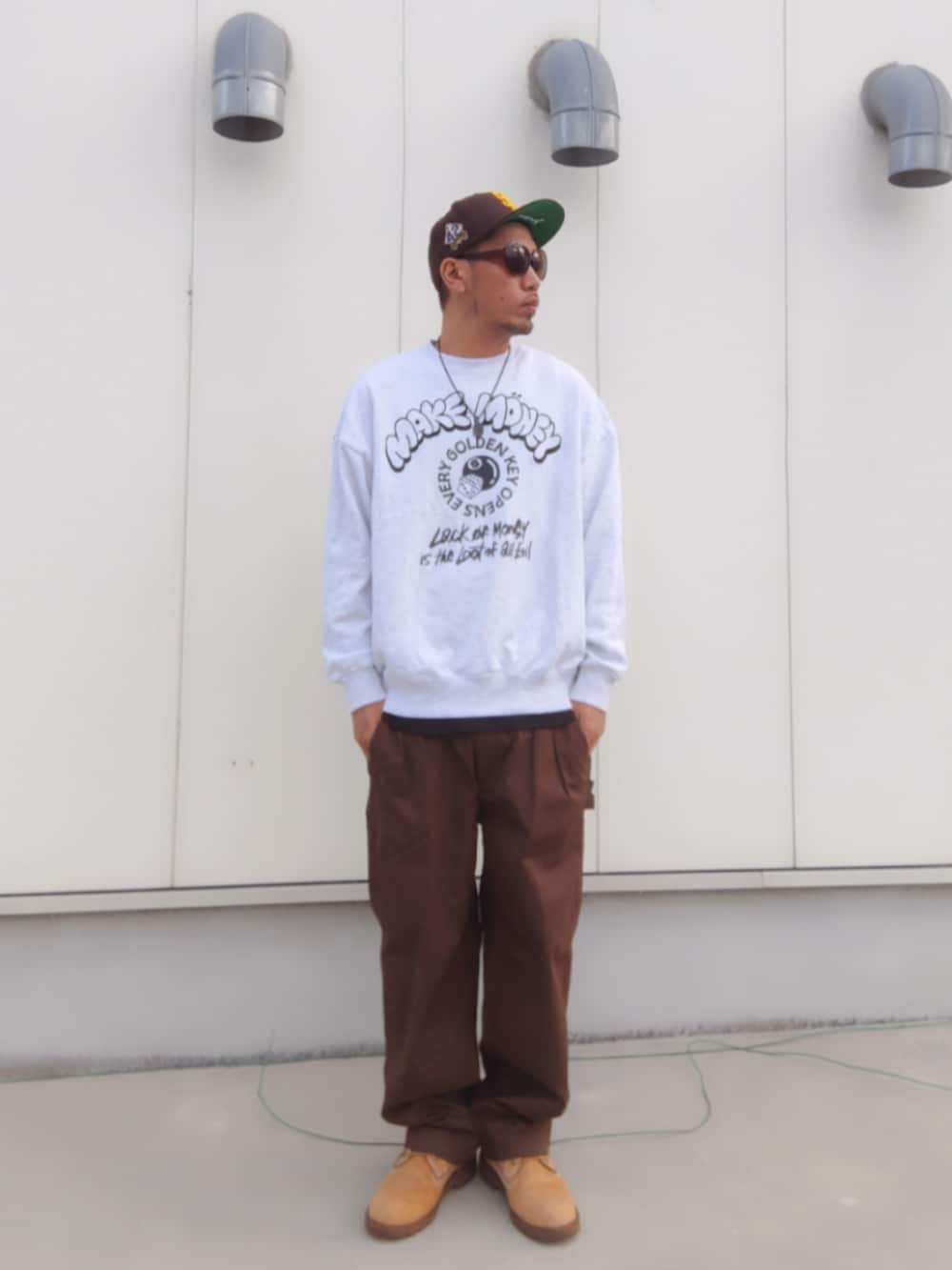 グレー系のスウェット、ブラック系のタンクトップ、ブラウン系のその他パンツを着用したメンズの秋コーディネートの2枚目の写真