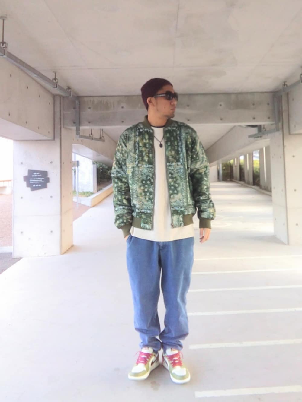 グリーン系のジャケット/アウター、ホワイト系のニット/セーター、ブルー系のデニムパンツを着用したメンズの冬コーディネートの3枚目の写真