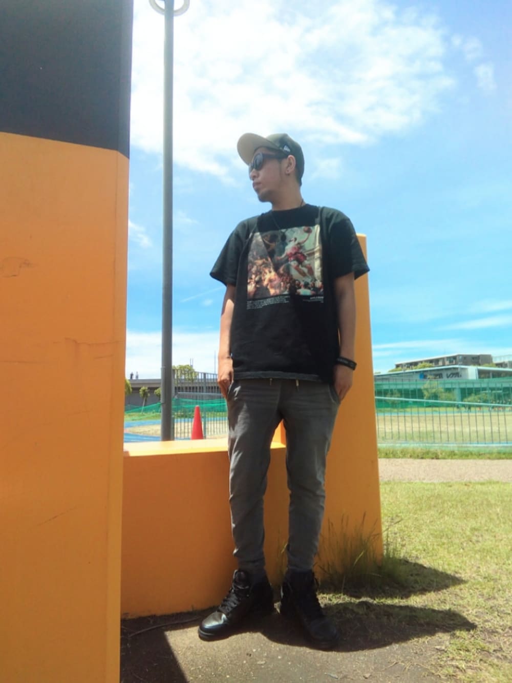 ブラック系のTシャツ/カットソー、ベージュ系のチノパンツ、ホワイト系のスニーカーを着用したメンズの夏コーディネートの4枚目の写真