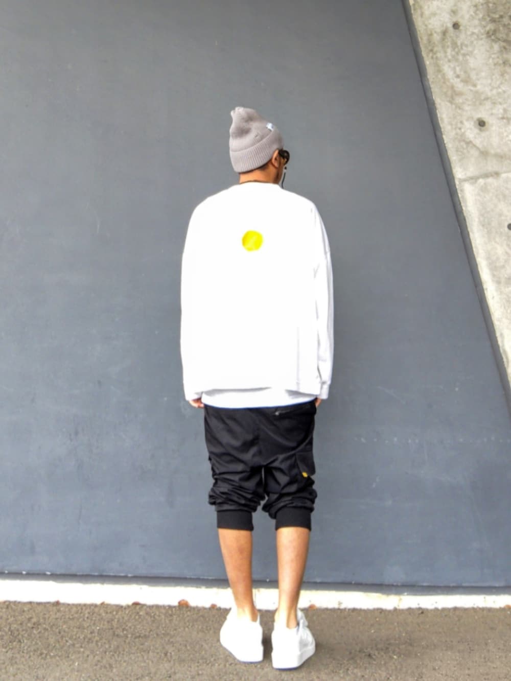 ホワイト系のTシャツ/カットソー、ブラック系のカーゴパンツ、ホワイト系のスニーカーを着用したメンズの夏コーディネートの3枚目の写真