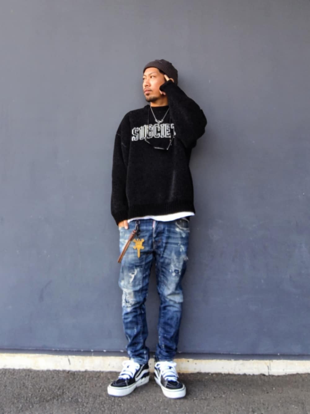 ブラック系のニット/セーター、ホワイト系のTシャツ/カットソー、ブラック系のスニーカーを着用したメンズの冬コーディネートの3枚目の写真