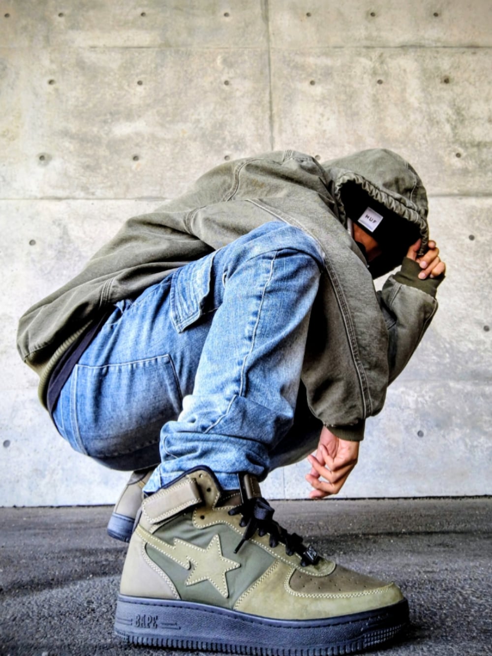 グリーン系のジャケット/アウター、ブラック系のTシャツ/カットソー、ブルー系のデニムパンツを着用したメンズの冬コーディネートの5枚目の写真