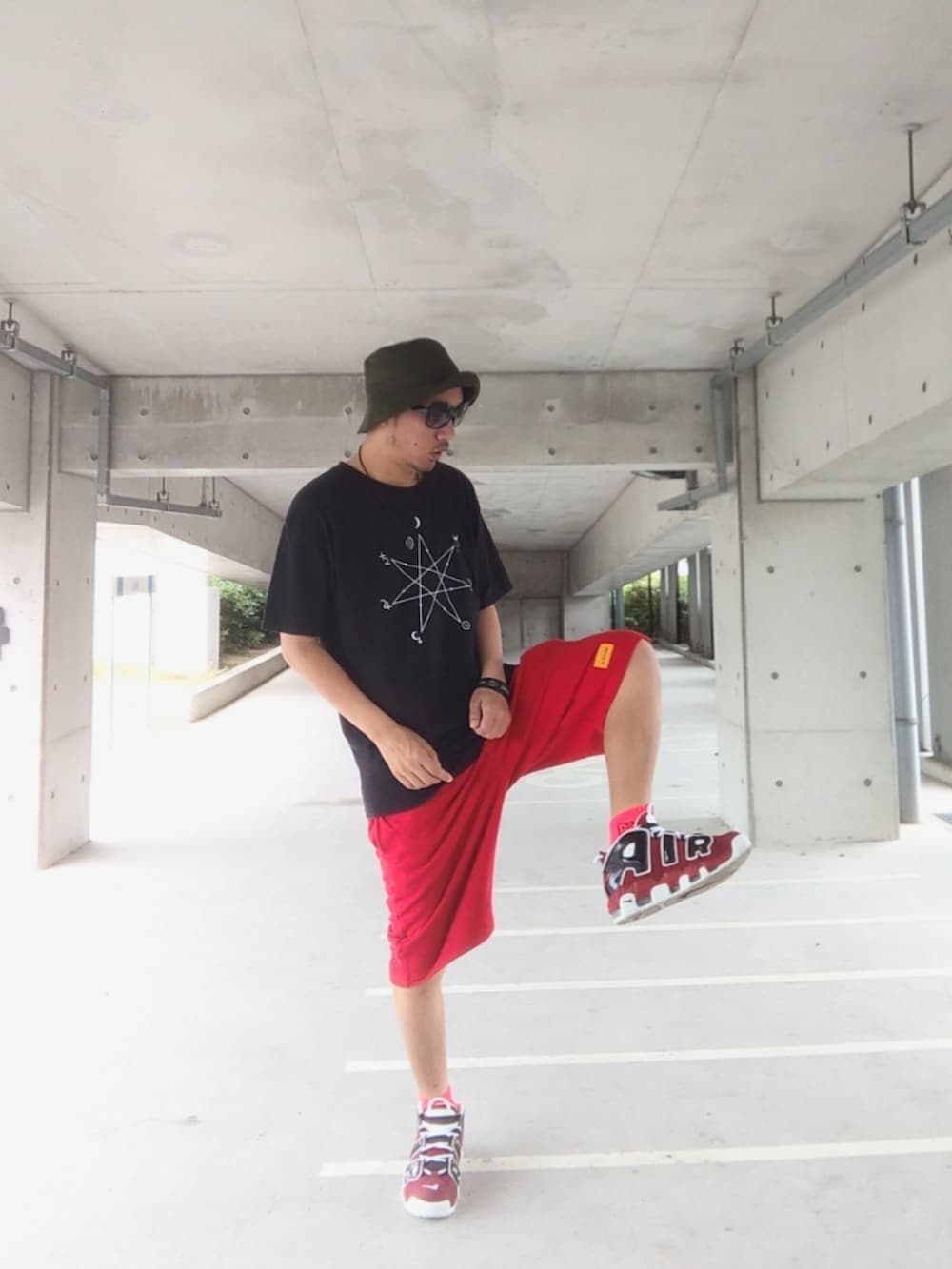 ブラック系のTシャツ/カットソー、レッド系のその他パンツ、レッド系のスニーカーを着用したメンズの夏コーディネートの2枚目の写真