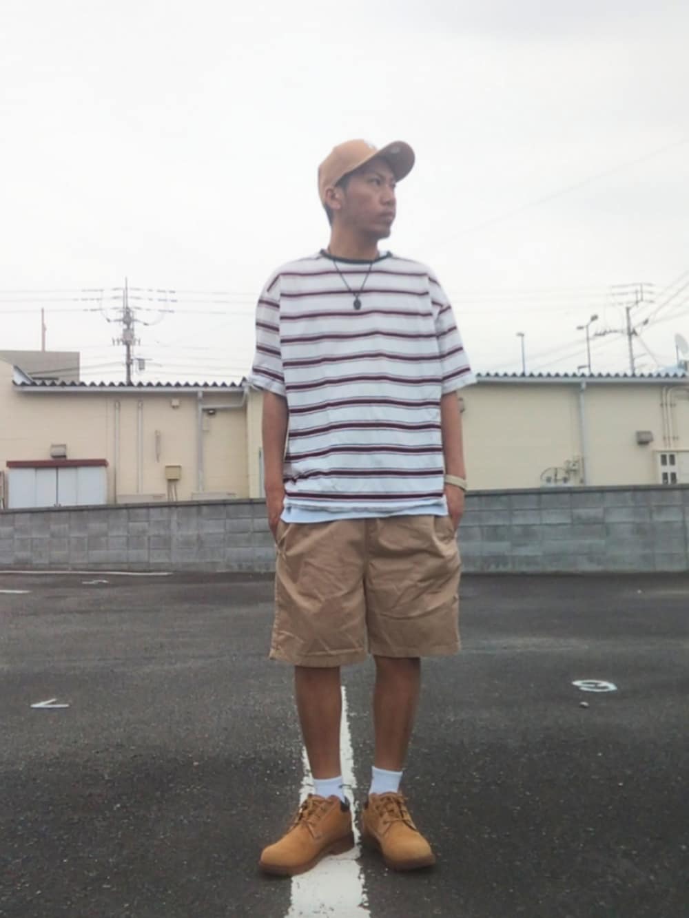 ホワイト系のTシャツ/カットソー、ベージュ系のチノパンツ、イエロー系のブーツを着用したメンズの春コーディネートの2枚目の写真