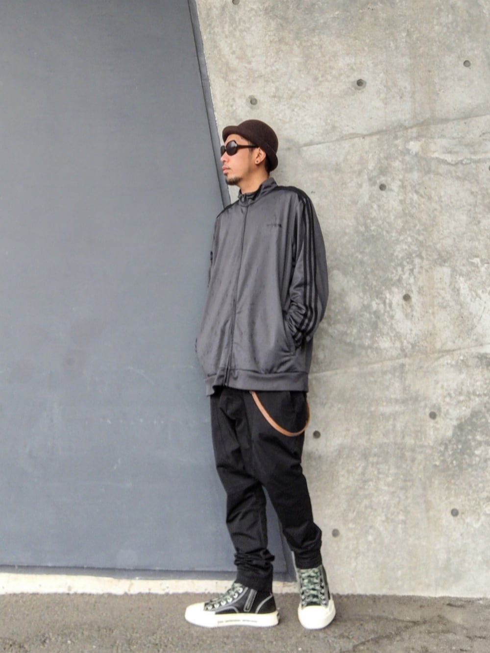 グレー系のジャージ、ブラック系のその他パンツ、ブラック系のスニーカーを着用したメンズの秋コーディネートの3枚目の写真