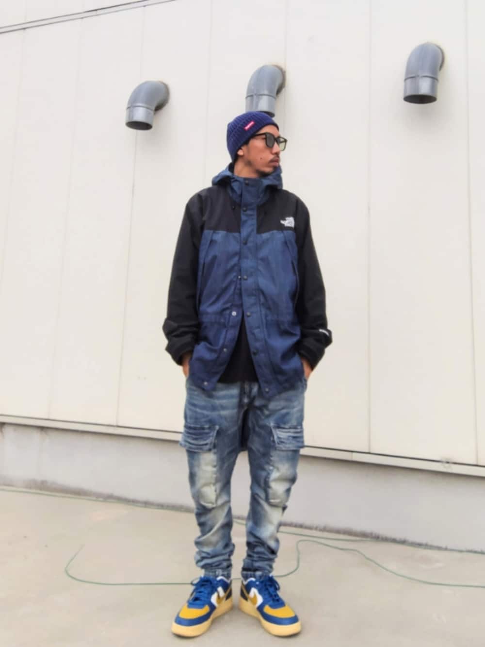 ブルー系のナイロンジャケット、ブルー系のデニムパンツ、その他のスニーカーを着用したメンズの冬コーディネートの2枚目の写真