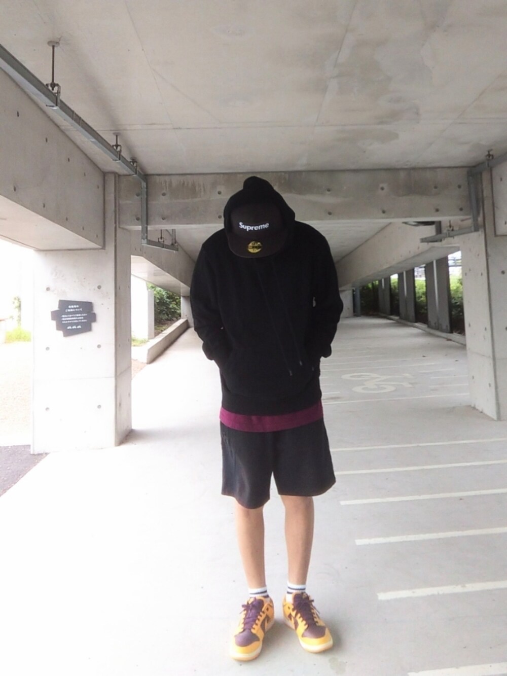 ブラック系のパーカー、ブラック系のその他パンツ、イエロー系のスニーカーを着用したメンズの秋コーディネートの2枚目の写真