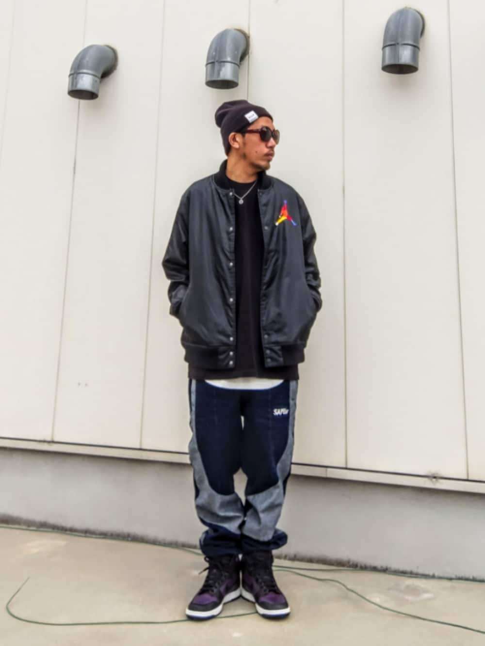 ブラック系のジャケット/アウター、ブラック系のスウェット、ブルー系のデニムパンツを着用したメンズの冬コーディネートの2枚目の写真