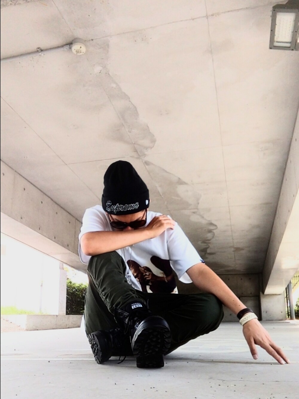 ホワイト系のTシャツ/カットソー、グリーン系のパンツ、ブラック系のブーツを着用したメンズの秋コーディネートの3枚目の写真