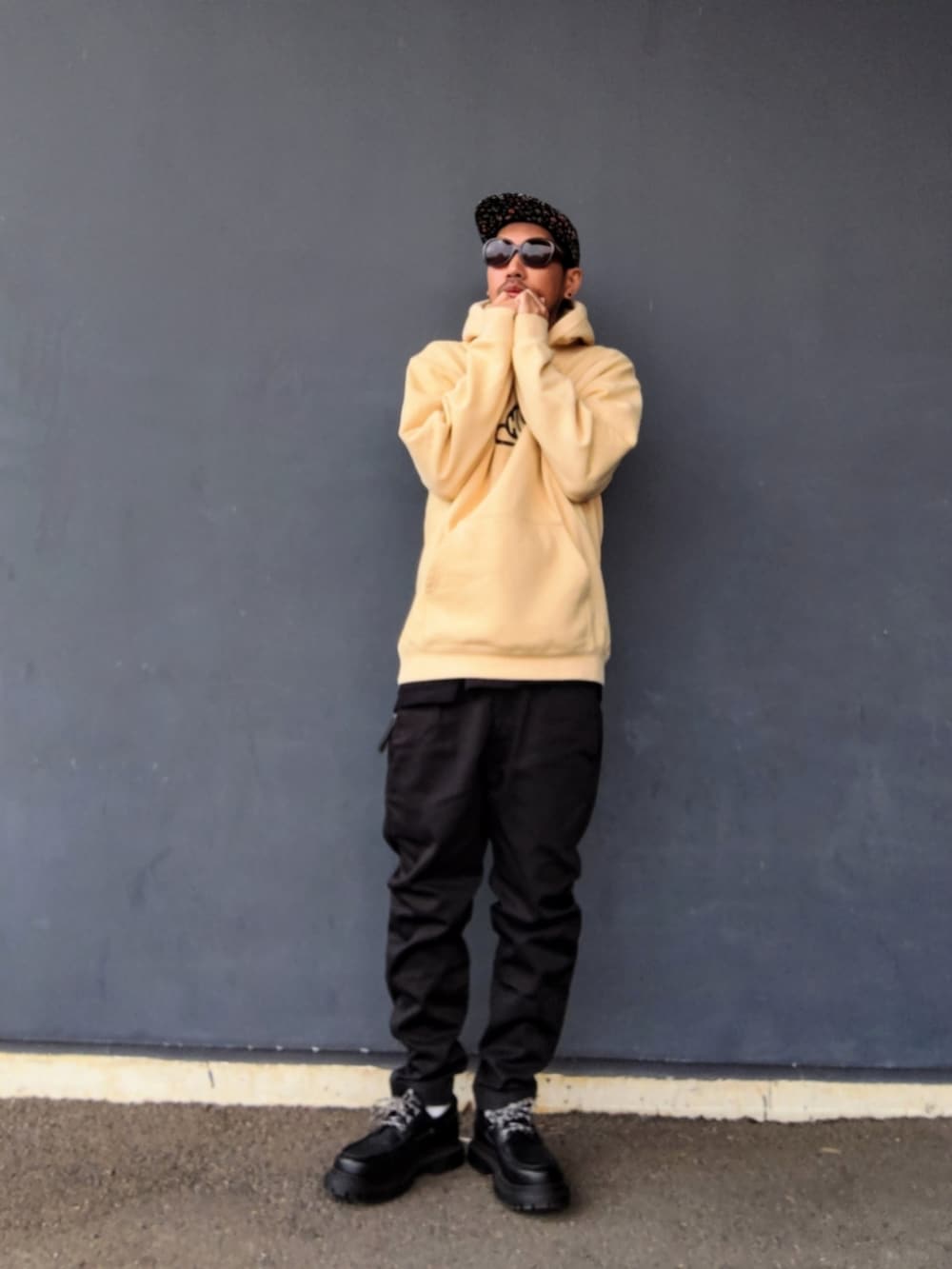 ベージュ系のパーカー、ブラック系のパンツ、ブラック系のモカシン/デッキシューズを着用したメンズの冬コーディネートの2枚目の写真