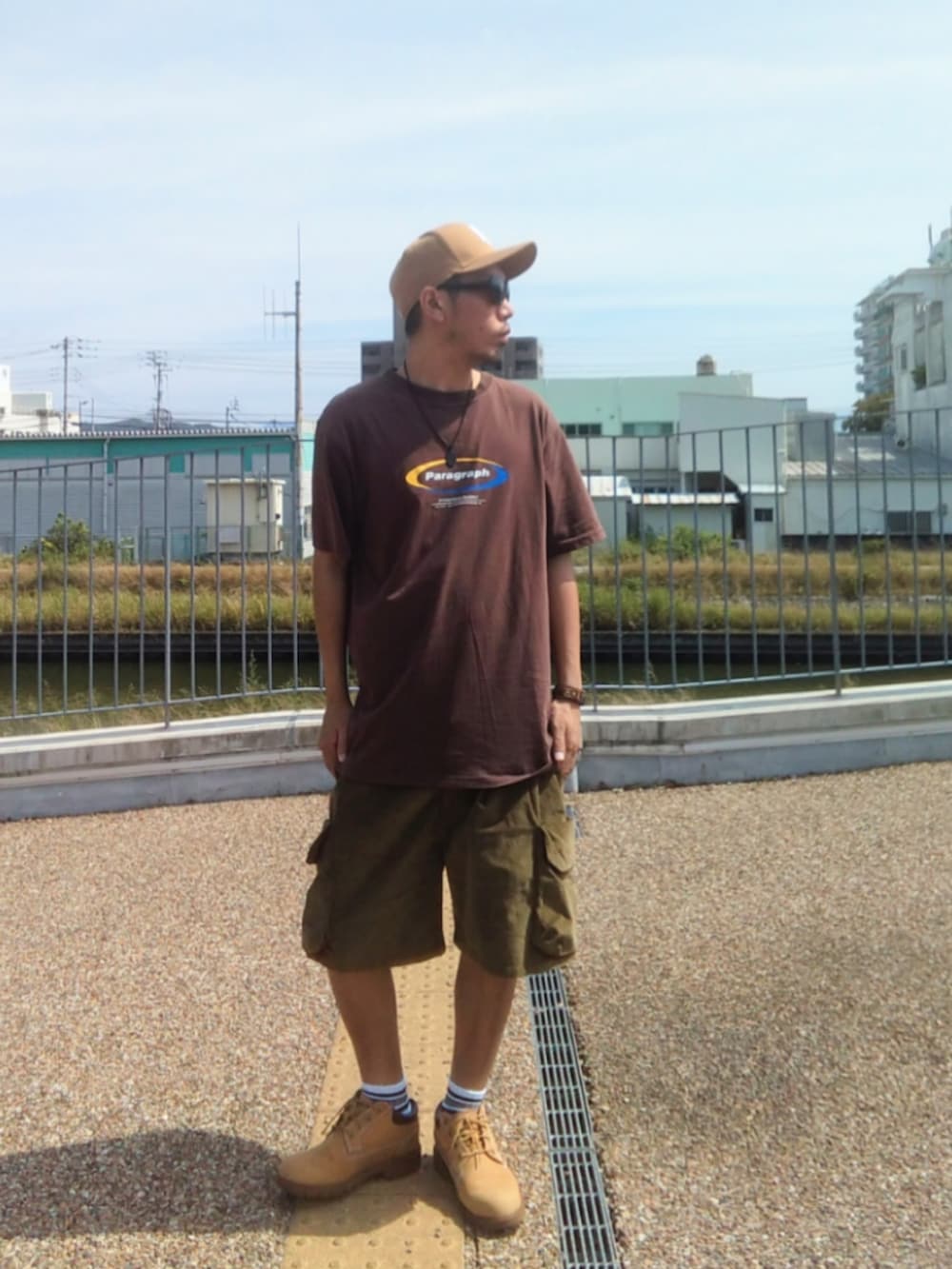 イエロー系のTシャツ/カットソー、その他のショルダーバッグ、グリーン系のカーゴパンツを着用したメンズの夏コーディネートの2枚目の写真