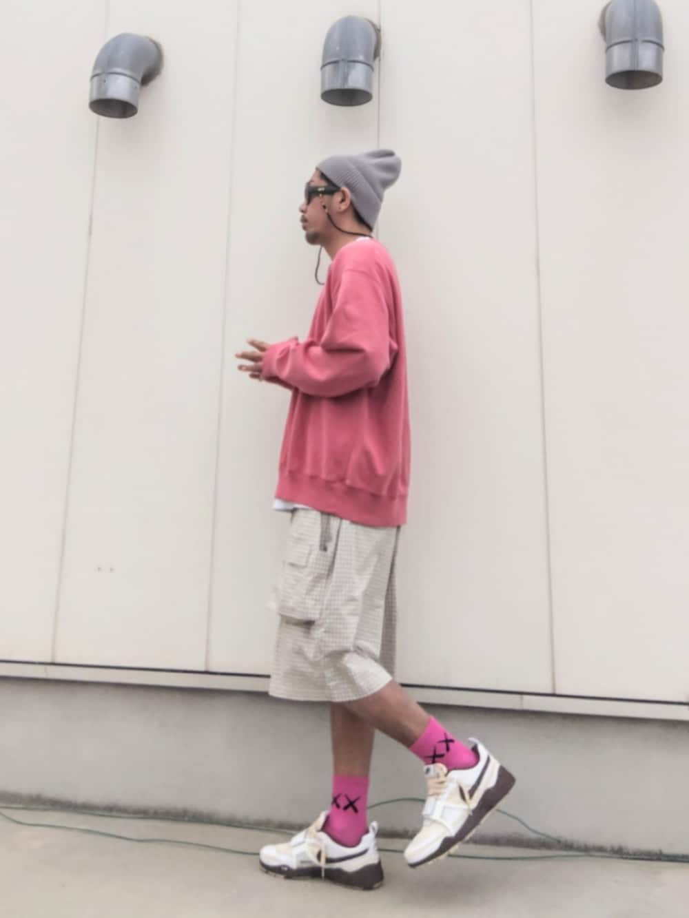 ピンク系のスウェット、ホワイト系のパンツ、ブラウン系のスニーカーを着用したメンズの春コーディネートの3枚目の写真