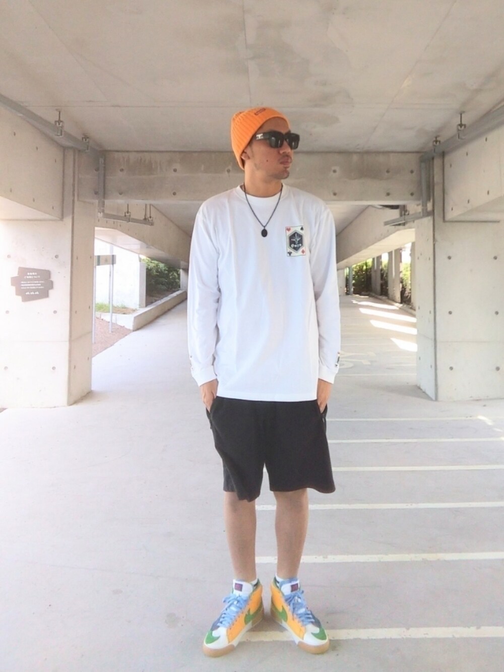 ホワイト系のTシャツ/カットソー、ブラック系のその他パンツ、オレンジ系のスニーカーを着用したメンズの秋コーディネートの3枚目の写真