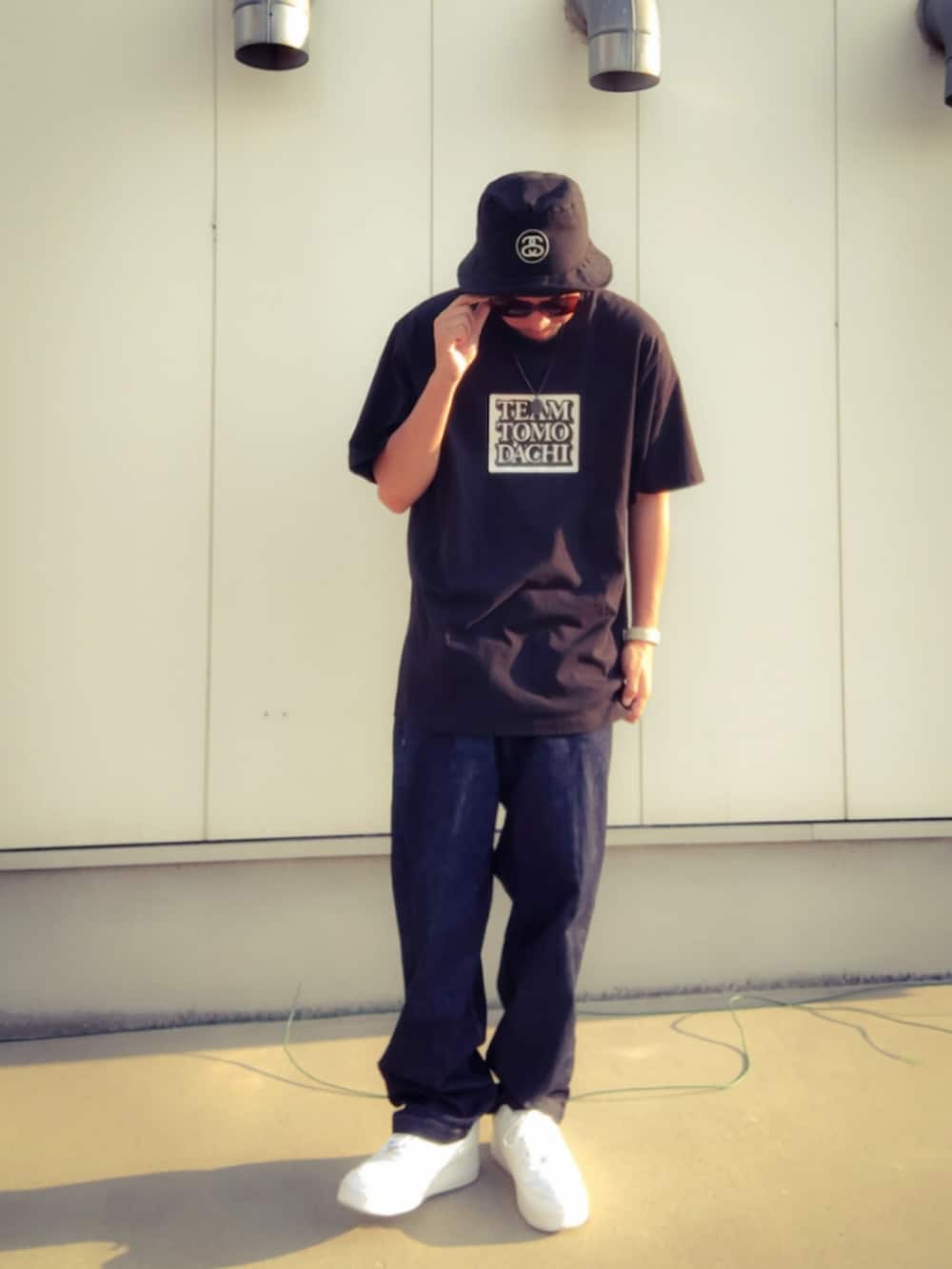 ブラック系のTシャツ/カットソー、ブルー系のデニムパンツ、ホワイト系のスニーカーを着用したメンズの秋コーディネートの2枚目の写真