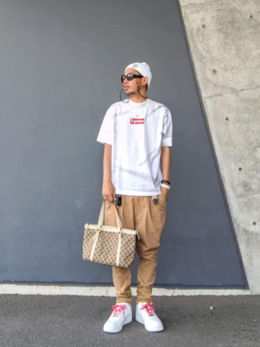 ホワイト系のTシャツ/カットソー、ベージュ系のトートバッグ、ベージュ系のその他パンツを着用したメンズの夏コーディネートの2枚目の写真