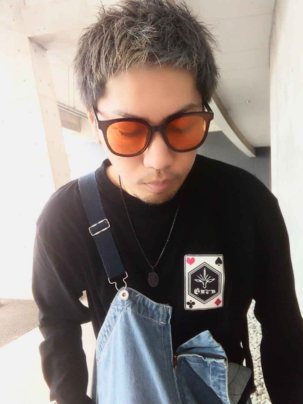 ブラック系のTシャツ/カットソー、ブルー系のサロペット/オーバーオール、イエロー系のブーツを着用したメンズの春コーディネートの3枚目の写真