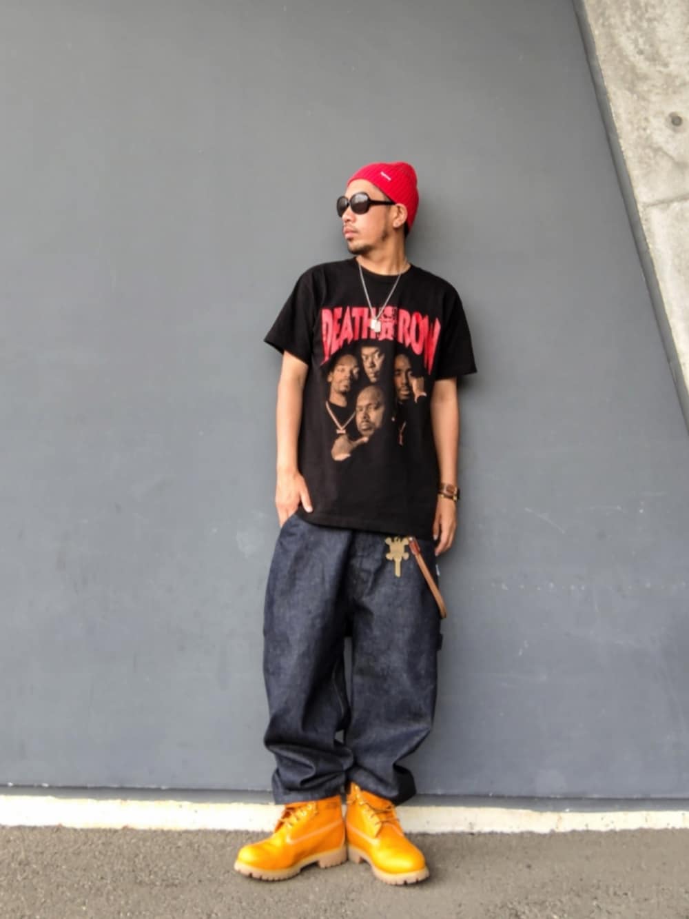 ブラック系のTシャツ/カットソー、ブルー系のデニムパンツ、イエロー系のブーツを着用したメンズの夏コーディネートの2枚目の写真