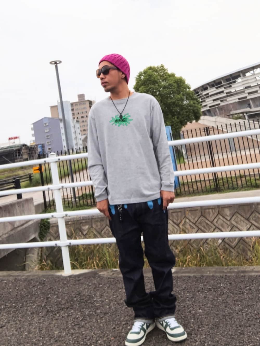 グレー系のTシャツ/カットソー、ブルー系のデニムパンツ、ホワイト系のスニーカーを着用したメンズの秋コーディネートの2枚目の写真