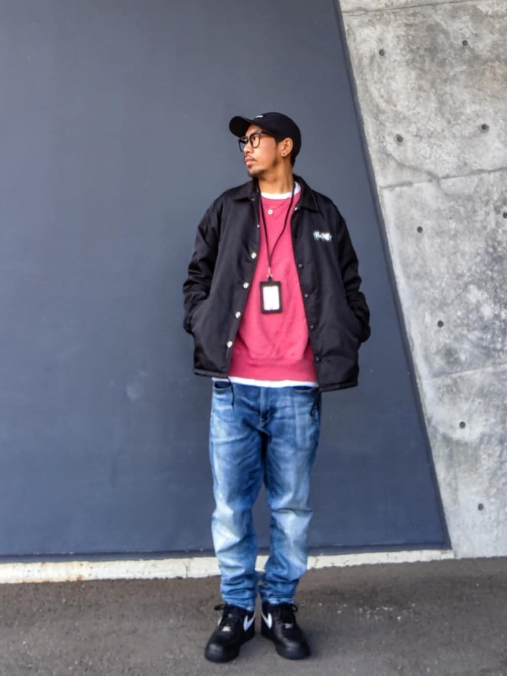 ブラック系のナイロンジャケット、ピンク系のスウェット、ブルー系のデニムパンツを着用したメンズの冬コーディネートの3枚目の写真