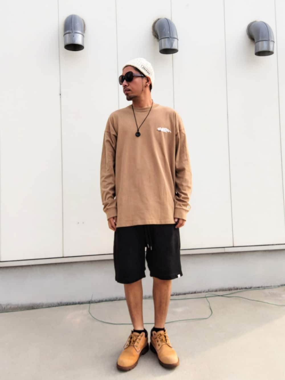 ベージュ系のTシャツ/カットソー、ブラック系のその他パンツ、イエロー系のブーツを着用したメンズの秋コーディネートの2枚目の写真