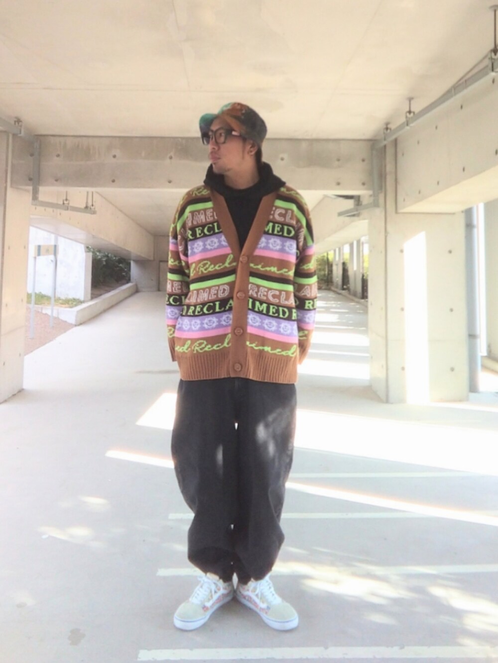 ブラック系のパーカー、ブラウン系のカーディガン/ボレロ、ブラック系のデニムパンツを着用したメンズの冬コーディネートの2枚目の写真