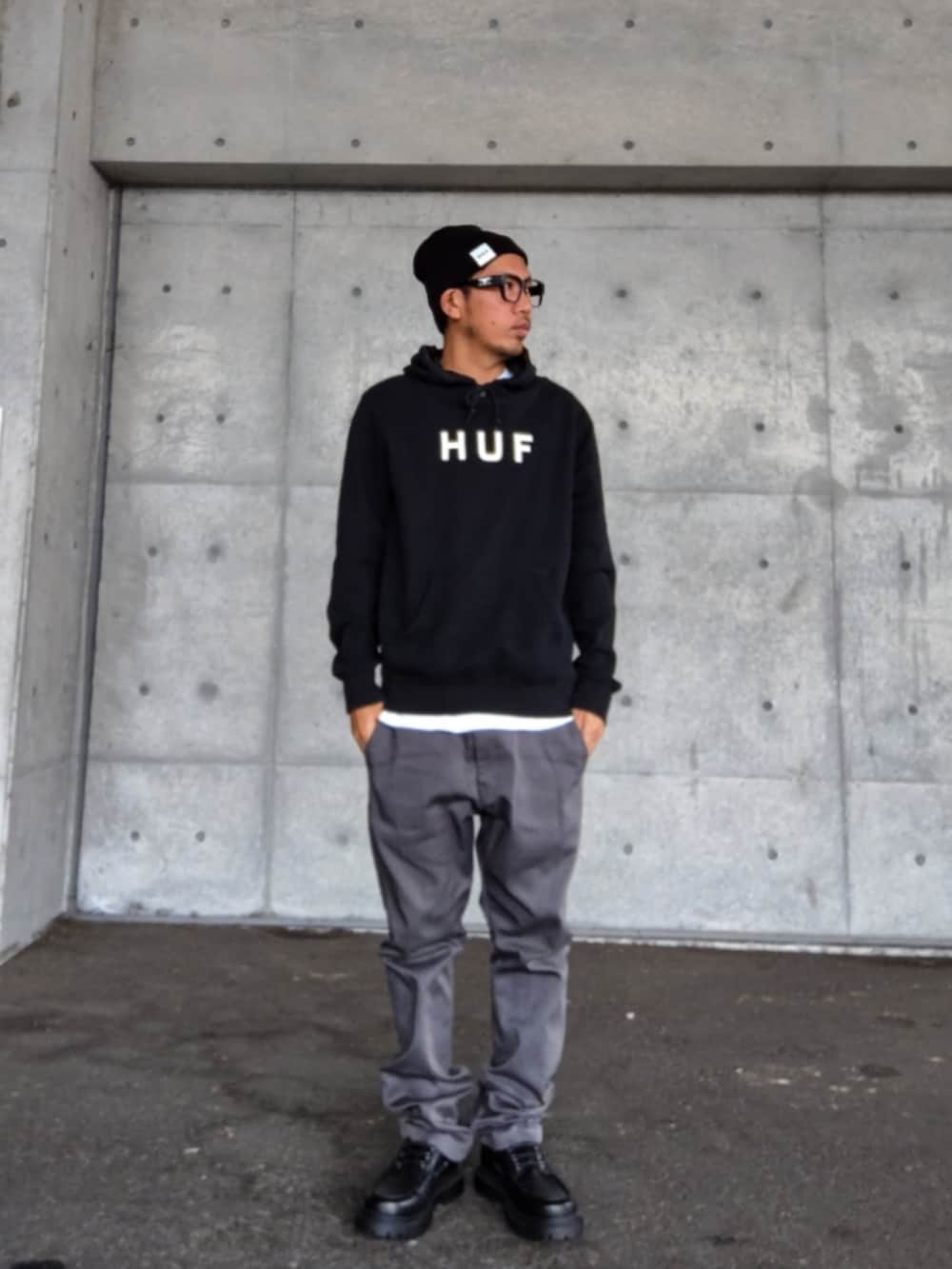 ブラック系のパーカー、ホワイト系のTシャツ/カットソー、グレー系のチノパンツを着用したメンズの秋コーディネートの2枚目の写真