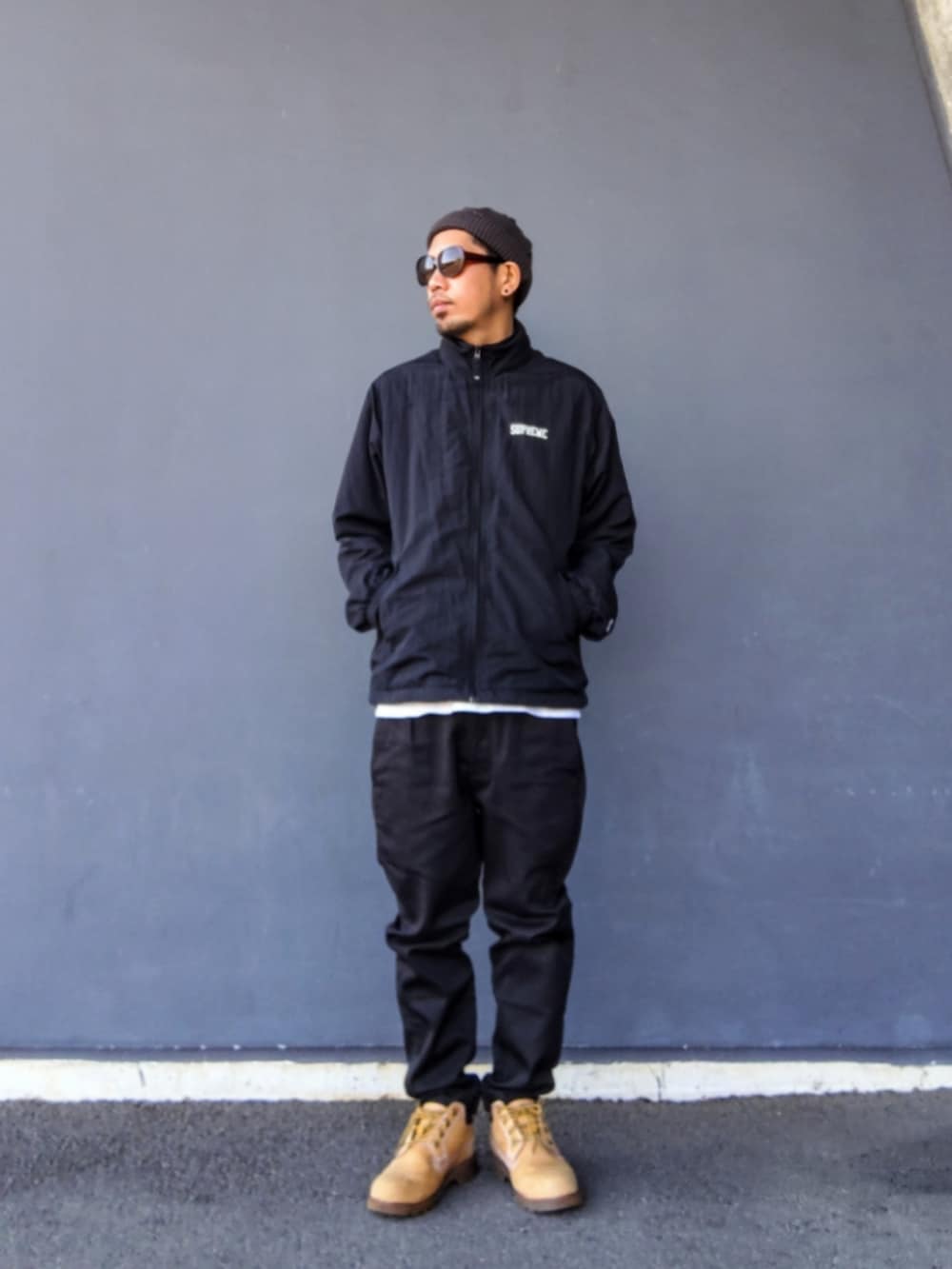 ブラック系のその他アウター、ブラック系のパンツ、イエロー系のブーツを着用したメンズの春コーディネートの2枚目の写真