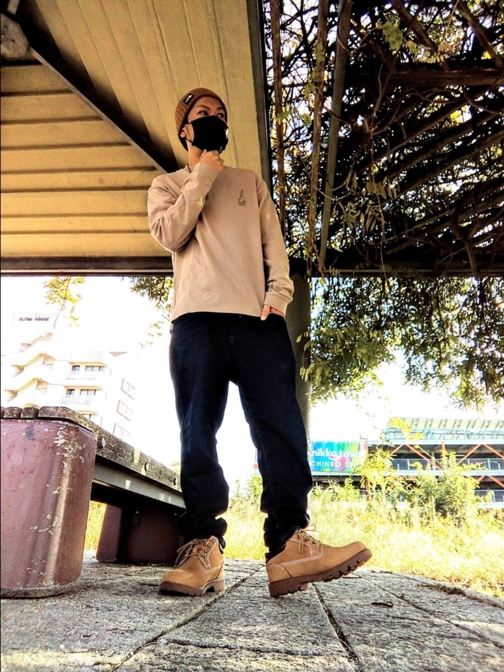 ベージュ系のTシャツ/カットソー、ブルー系のデニムパンツ、イエロー系のブーツを着用したメンズの秋コーディネートの3枚目の写真