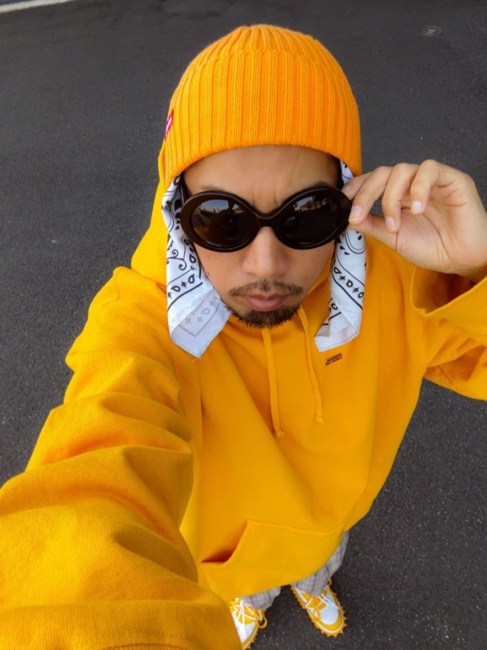 イエロー系のパーカー、ベージュ系のその他パンツ、イエロー系のスニーカーを着用したメンズの冬コーディネートの3枚目の写真