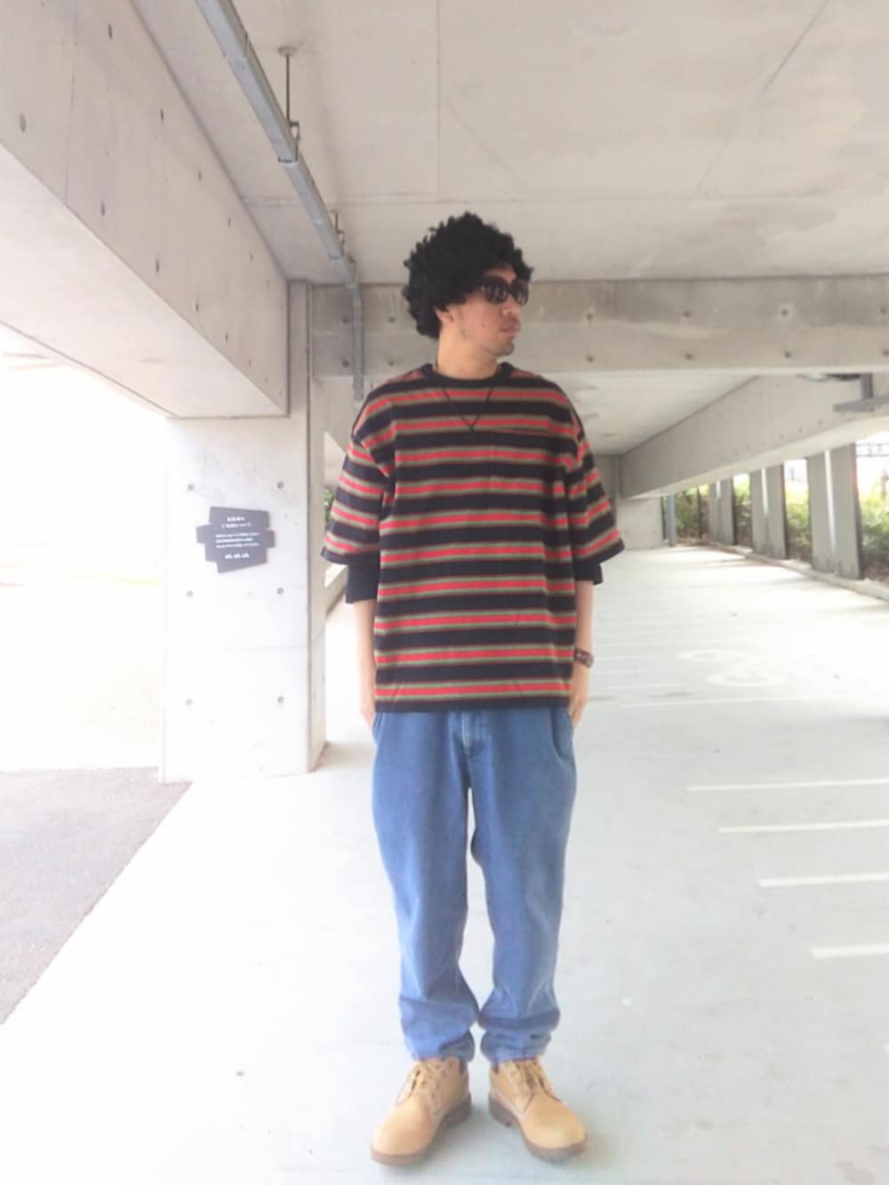 ブラック系のTシャツ/カットソー、ブルー系のデニムパンツ、イエロー系のブーツを着用したメンズの春コーディネートの3枚目の写真