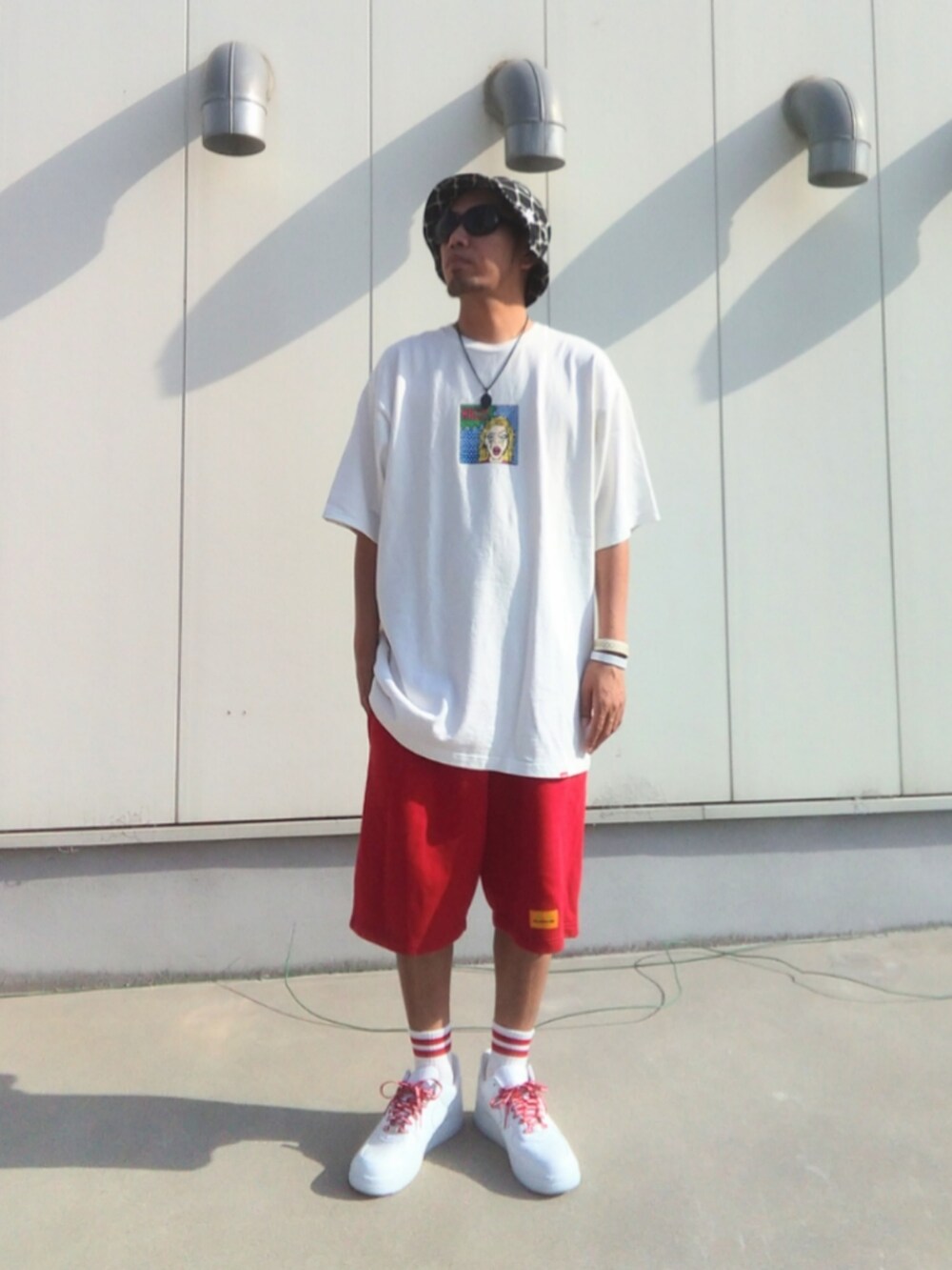 ホワイト系のTシャツ/カットソー、レッド系のその他パンツ、ホワイト系のスニーカーを着用したメンズの夏コーディネートの2枚目の写真