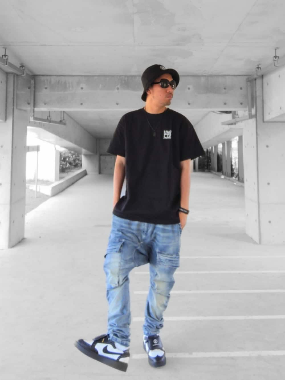 ブラック系のTシャツ/カットソー、ブルー系のデニムパンツ、ブラック系のスニーカーを着用したメンズの夏コーディネートの2枚目の写真