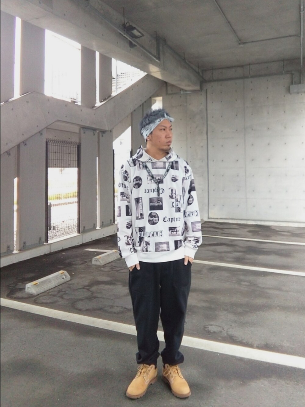 ブラック系のスウェットパンツ、イエロー系のブーツ、ホワイト系のパーカーを着用したメンズの春コーディネートの3枚目の写真