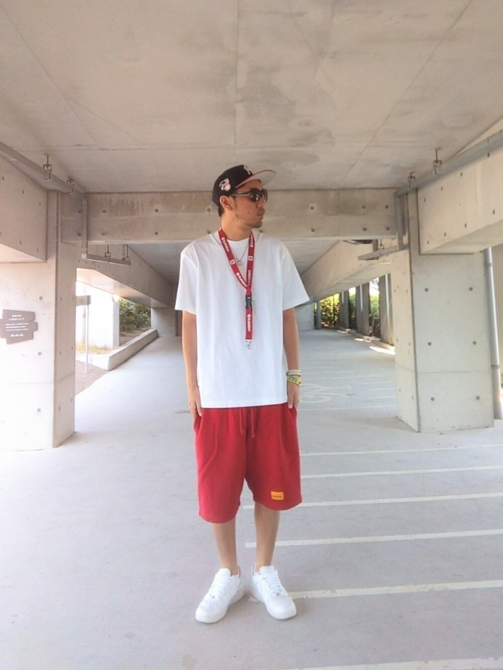 ホワイト系のTシャツ/カットソー、レッド系のその他パンツ、ホワイト系のスニーカーを着用したメンズの夏コーディネートの2枚目の写真