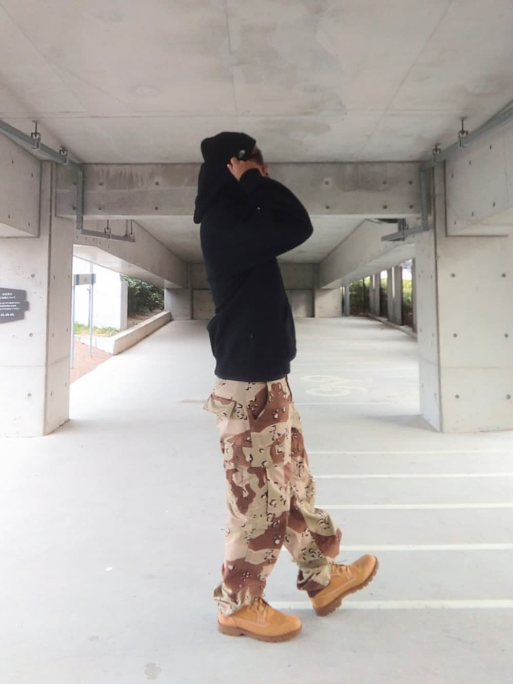 ブラック系のパーカー、その他のカーゴパンツ、イエロー系のブーツを着用したメンズの冬コーディネートの3枚目の写真